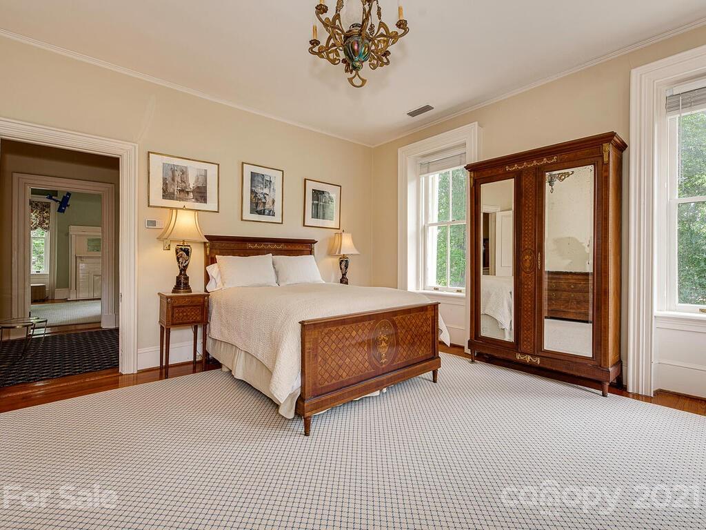 1700 Queens Road Charlotte, NC 28207 - Photo 32 of 48 a bedroom with a large bed and a chandelier fan