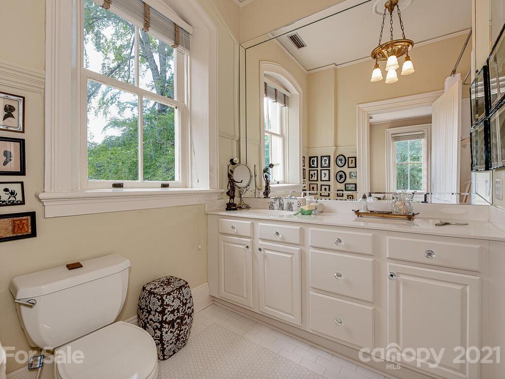 1700 Queens Road Charlotte, NC 28207 - Photo 34 of 48 a bathroom with a granite countertop toilet sink and mirror