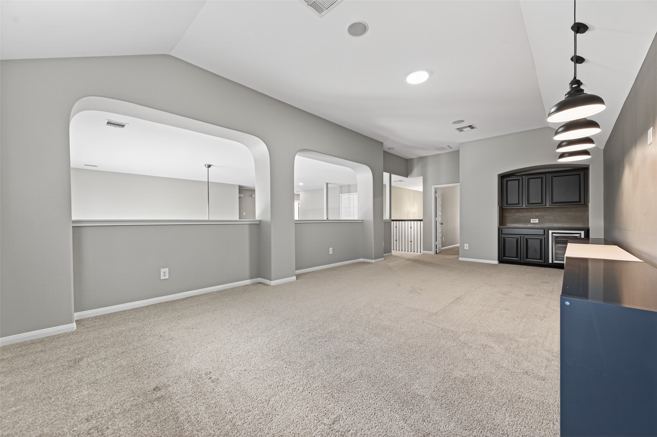 7003 Bristol Memorial Drive Spring, TX 77379 - Photo 27 of 40 Alternate view of the expansive second-floor game room in this Spring TX 77379 home, highlighting the generous square footage and open wall space for media setup or custom built-ins. Elevated ceilings and recessed lighting enhance the bright, open feel, while soft carpeting adds comfort. Positioned on the upper level for added privacy, this versatile space offers flexibility for entertainment, work, or additional living area in this spacious home near The Woodlands.