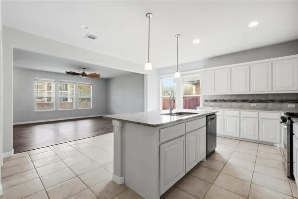 a kitchen with a sink window and cabinets
