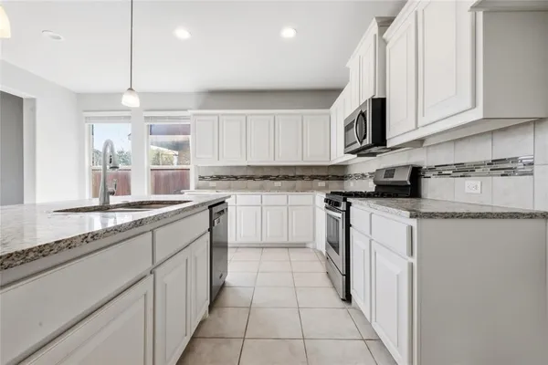 a kitchen with stainless steel appliances granite countertop a sink and cabinets