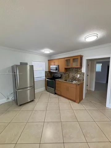 a kitchen with stainless steel appliances granite countertop a refrigerator and a stove