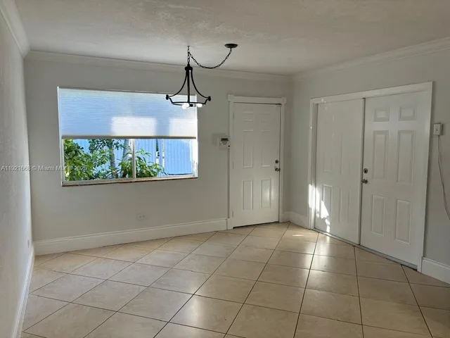 a view of a hallway with a chandelier fan and windows