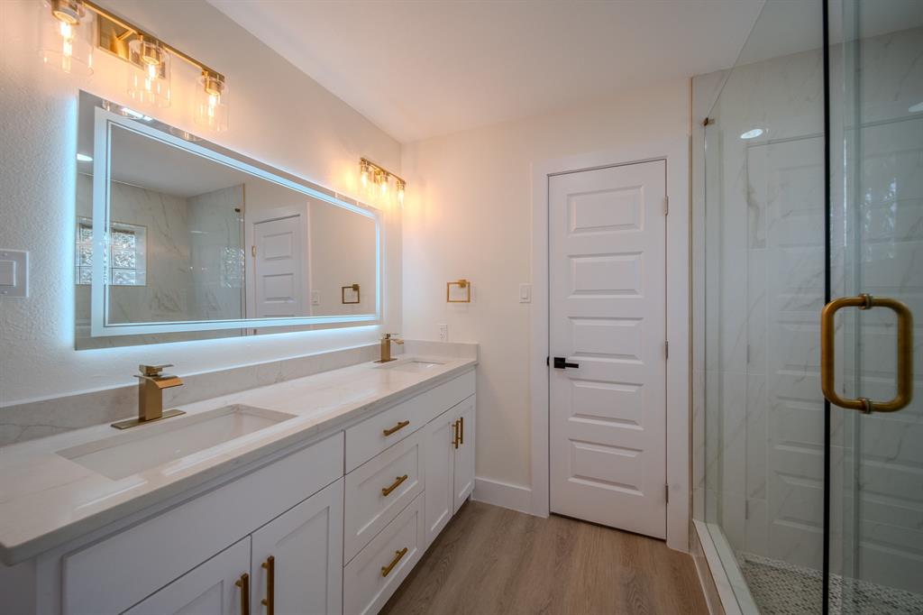 142 Ridgegate Drive Garland, TX 75040 - Photo 21 of 26 Double vanity with white cabinetry, gold-finish hardware, and integrated rectangular sinks