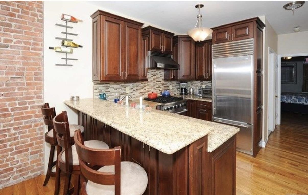 211 14th Street, Unit 2R Hoboken, NJ 07030 - Photo 2 of 10 a kitchen with a table chairs sink and refrigerator
