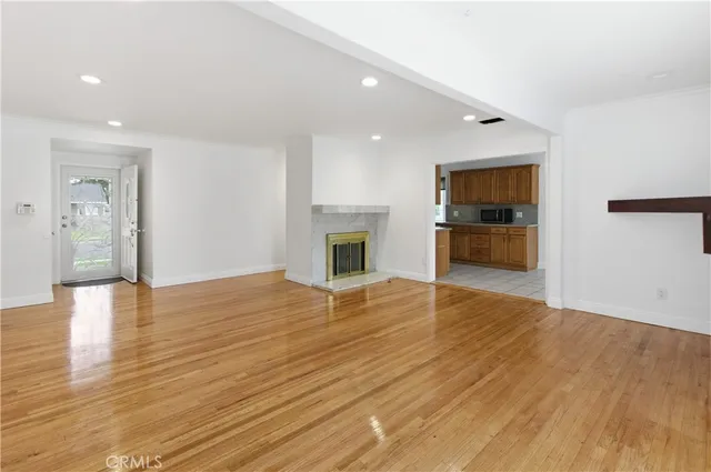 a view of empty room with wooden floor and fireplace