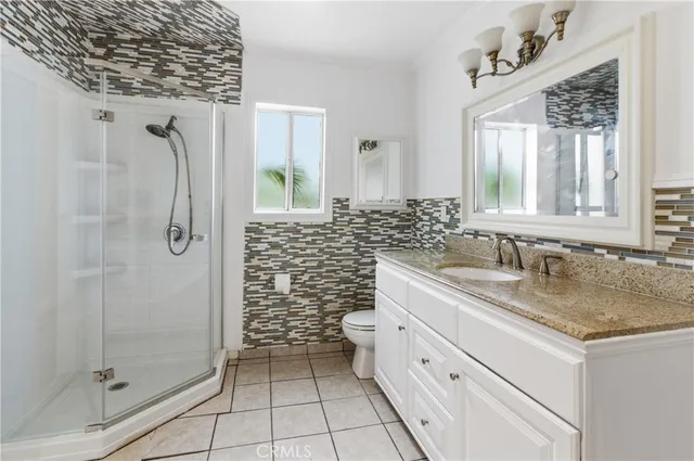 a bathroom with a granite countertop sink a shower and a mirror