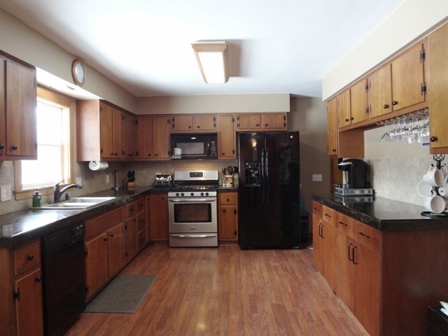12920 Base Line Road Kingston, IL 60145 - Photo 4 of 25 a kitchen with stainless steel appliances kitchen island granite countertop a refrigerator stove and sink