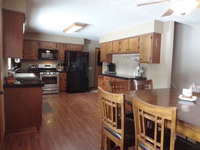 12920 Base Line Road Kingston, IL 60145 - Photo 5 of 25 a kitchen with stainless steel appliances granite countertop a refrigerator a stove and a sink