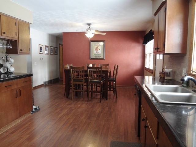 12920 Base Line Road Kingston, IL 60145 - Photo 7 of 25 a kitchen with stainless steel appliances granite countertop a kitchen island hardwood floor sink stove dining table and chairs