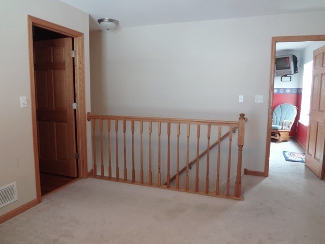 12920 Base Line Road Kingston, IL 60145 - Photo 9 of 25 a view of a hallway with wooden staircase