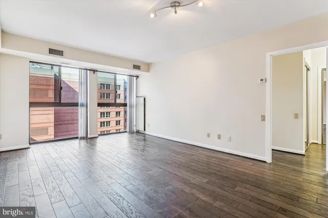 an empty room with wooden floor and closet