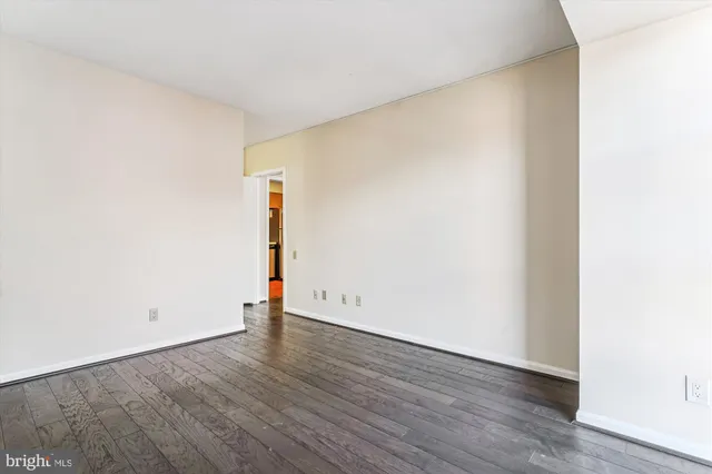 an empty room with wooden floor and window