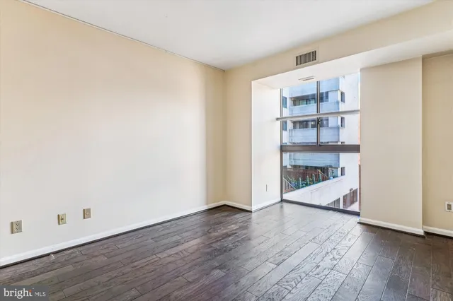 a view of a room with wooden floor and a window