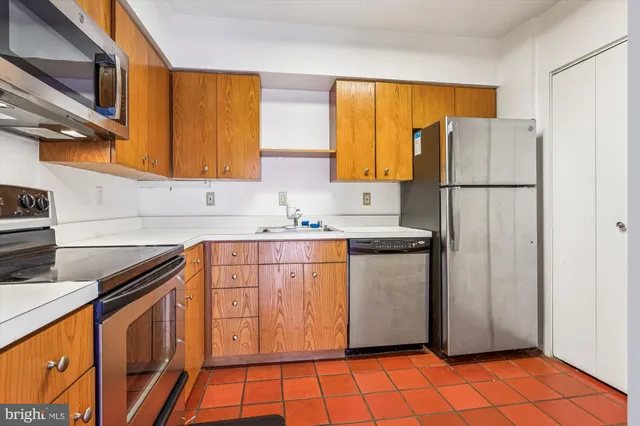a kitchen with stainless steel appliances granite countertop a refrigerator a stove a sink and dishwasher