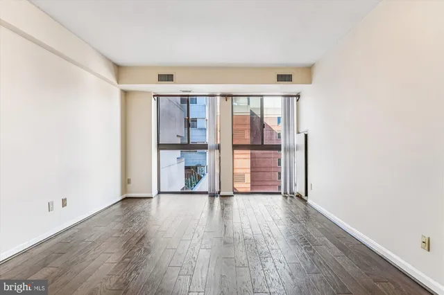 a view of empty room with wooden floor