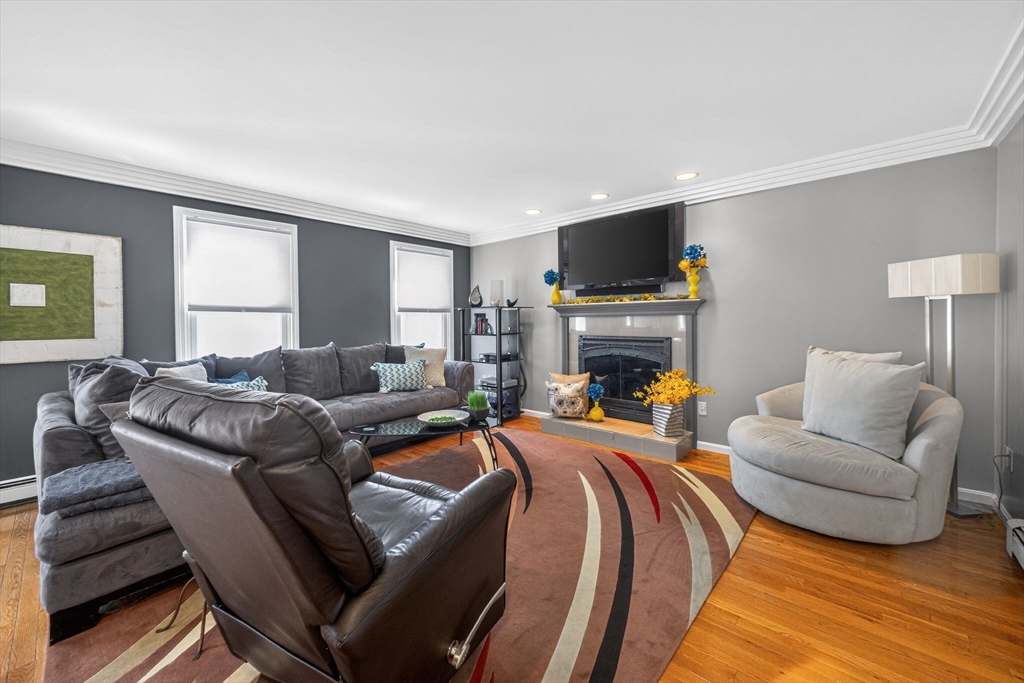 22 McRayne Hill Road Billerica, MA 01821 - Photo 16 of 42 a living room with furniture a flat screen tv and a fireplace
