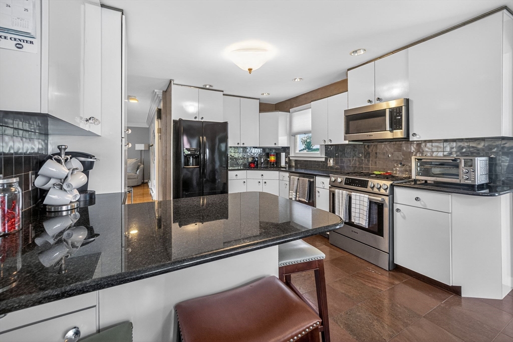22 McRayne Hill Road Billerica, MA 01821 - Photo 4 of 42 a kitchen with stainless steel appliances granite countertop a refrigerator a stove and a sink