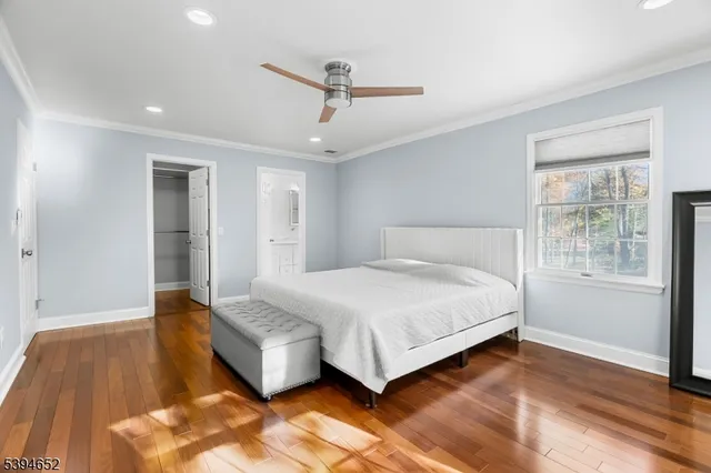 a spacious bedroom with a bed and wooden floor