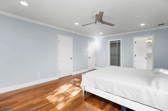 a spacious bedroom with a bed and a ceiling fan