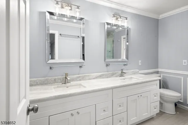 a bathroom with a granite countertop sink a toilet and a mirror