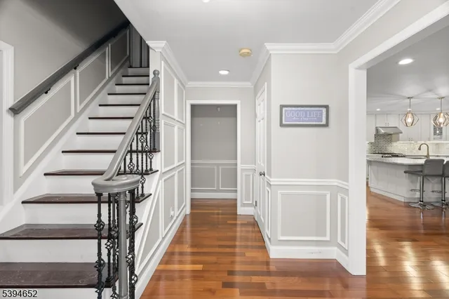 a view of entryway and hall with wooden floor