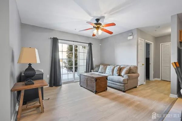 a living room with furniture a ceiling fan and a window