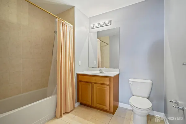 a bathroom with a granite countertop toilet sink and mirror