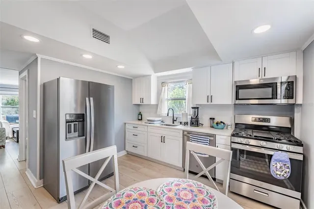 a kitchen with white cabinets and stainless steel appliances