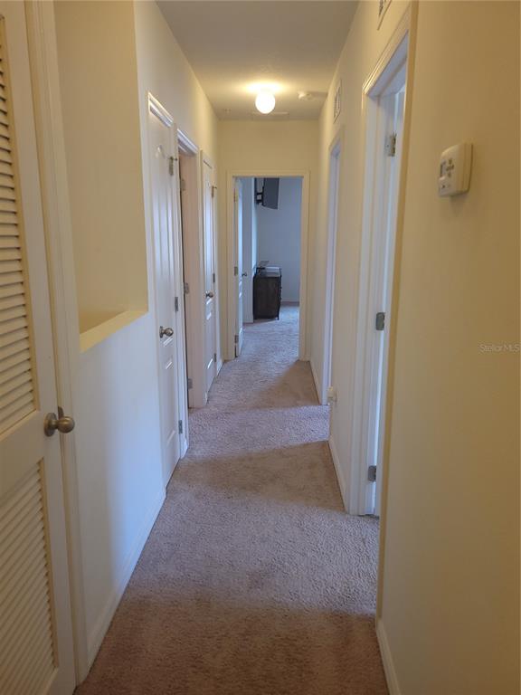 3724 Seneca Club Loop, Unit 41103 Orlando, FL 32808 - Photo 14 of 27 a view of a hallway with wooden shelves
