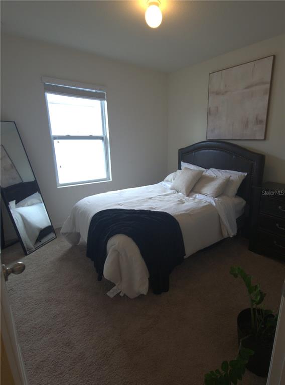 3724 Seneca Club Loop, Unit 41103 Orlando, FL 32808 - Photo 15 of 27 a bedroom with a bed and window
