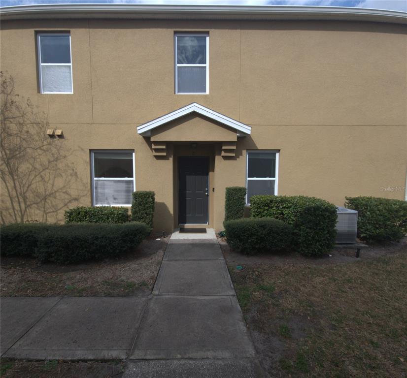 3724 Seneca Club Loop, Unit 41103 Orlando, FL 32808 - Photo 2 of 27 a front view of a house with a garden