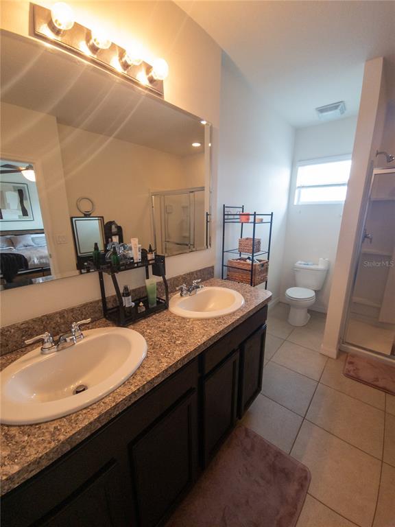 3724 Seneca Club Loop, Unit 41103 Orlando, FL 32808 - Photo 23 of 27 a bathroom with a granite countertop sink and a mirror