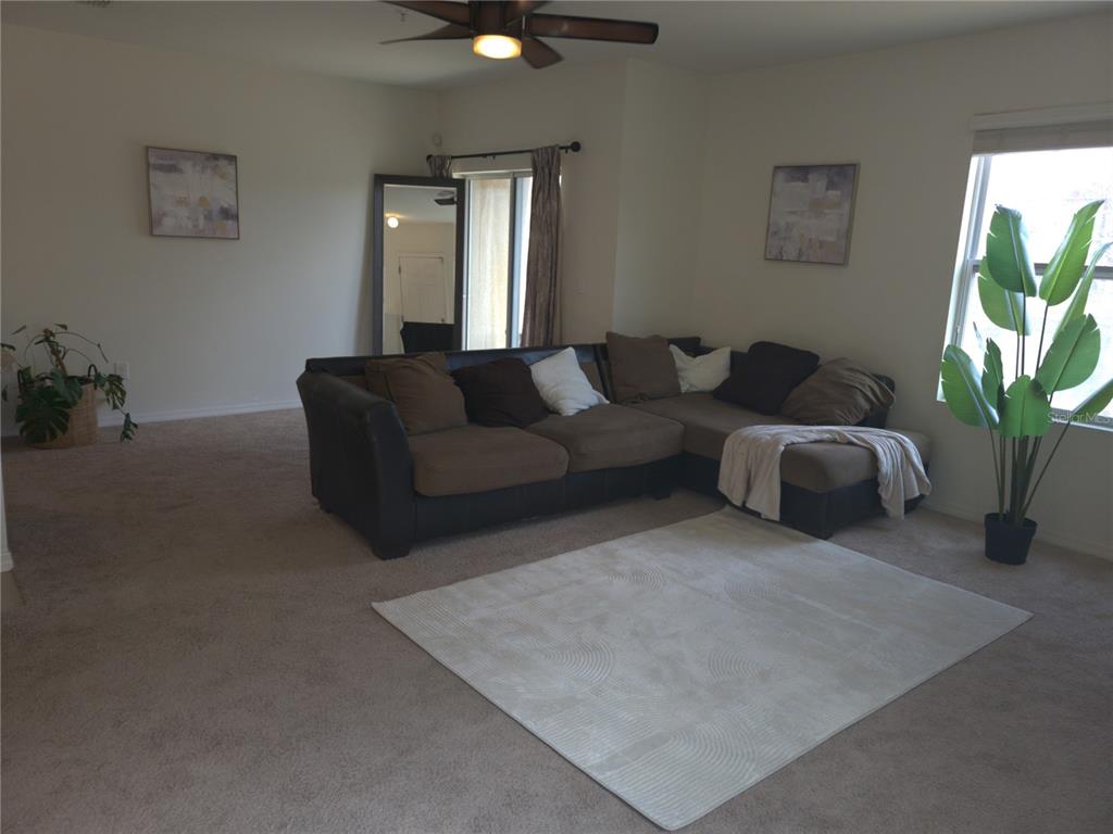 3724 Seneca Club Loop, Unit 41103 Orlando, FL 32808 - Photo 3 of 27 a living room with furniture and a potted plant