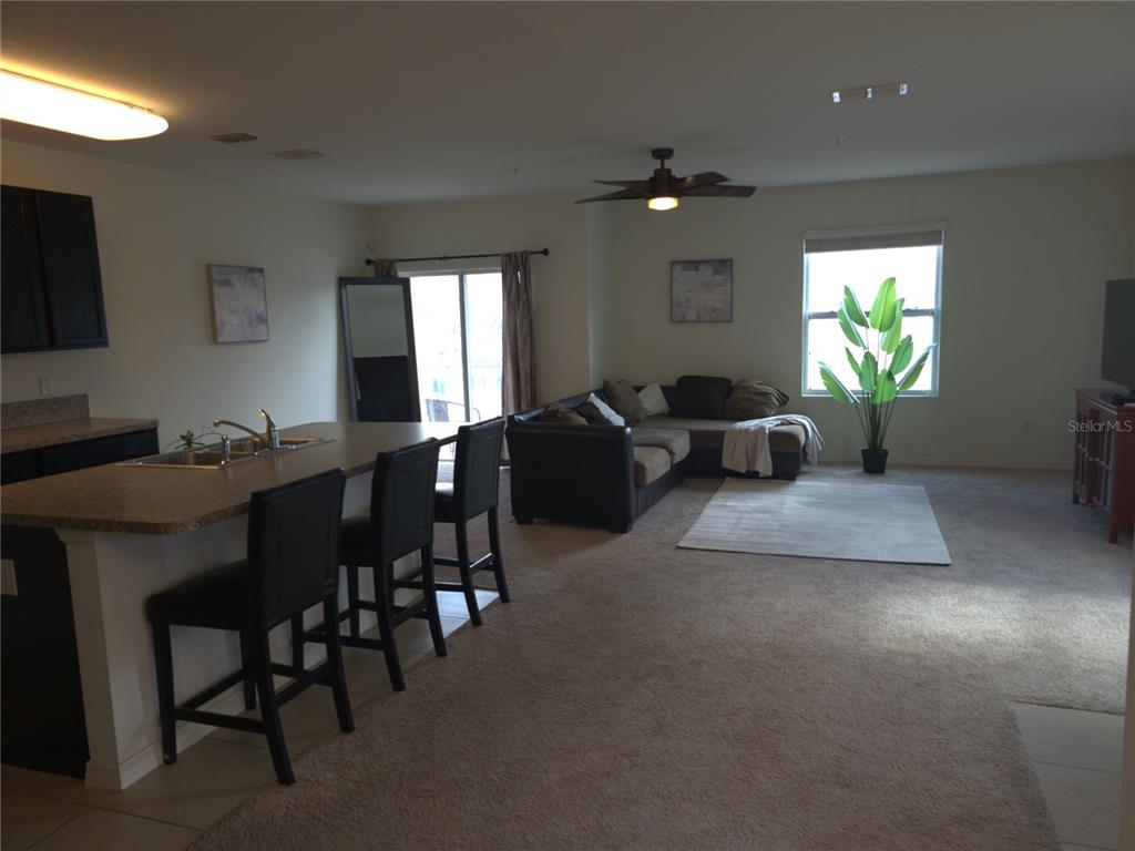 3724 Seneca Club Loop, Unit 41103 Orlando, FL 32808 - Photo 5 of 27 a living room with furniture a large window and a potted plant