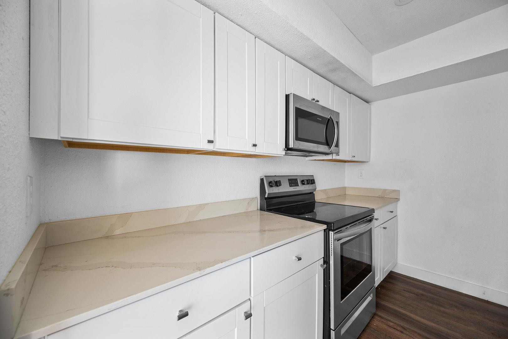 18202 North Cave Creek Road, Unit 252 Phoenix, AZ 85032 - Photo 2 of 15 a kitchen with granite countertop cabinets stainless steel appliances and wooden floor