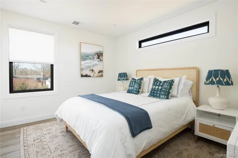 a bedroom with a bed and a painting on the wall