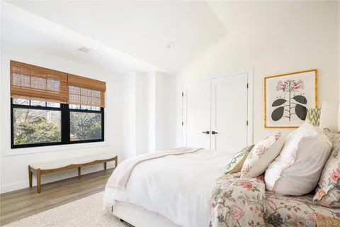 a bedroom with a bed and a painting on the wall