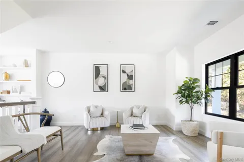 a living room with furniture potted plant and a large window