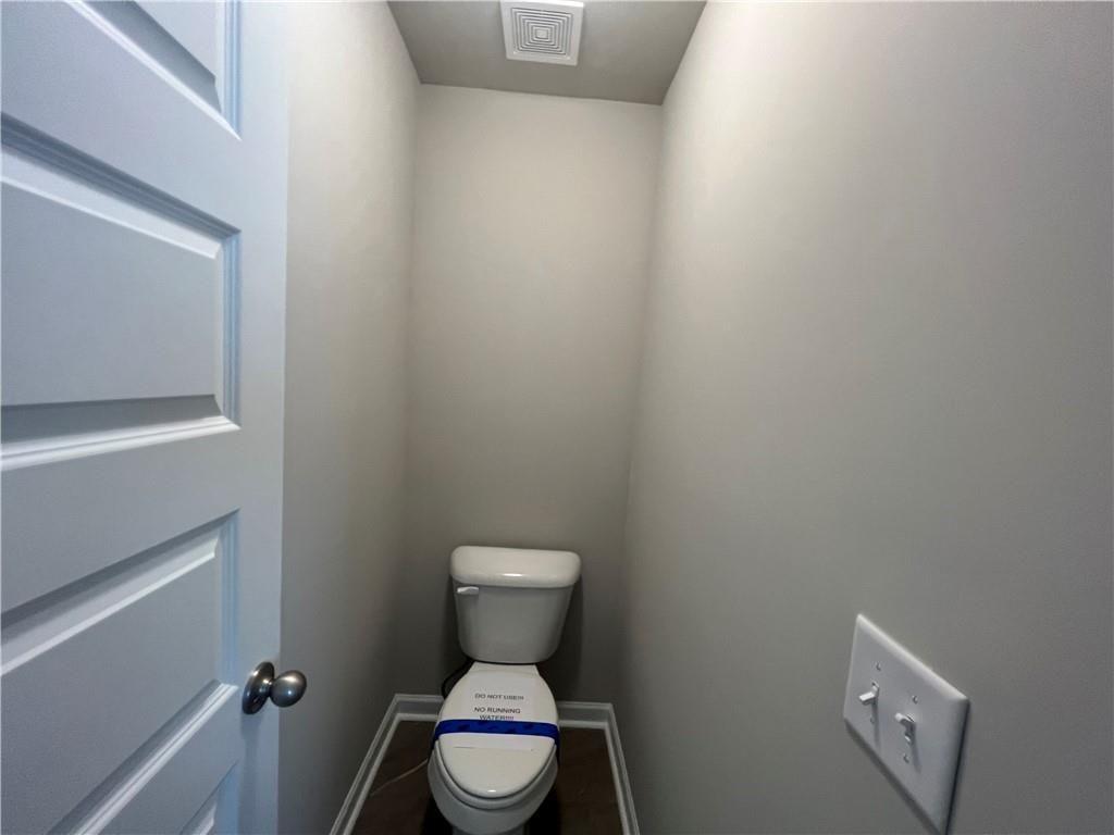 213 Cornwell Way Calhoun, GA 30701 - Photo 12 of 18 a white toilet sitting next to a white cabinet