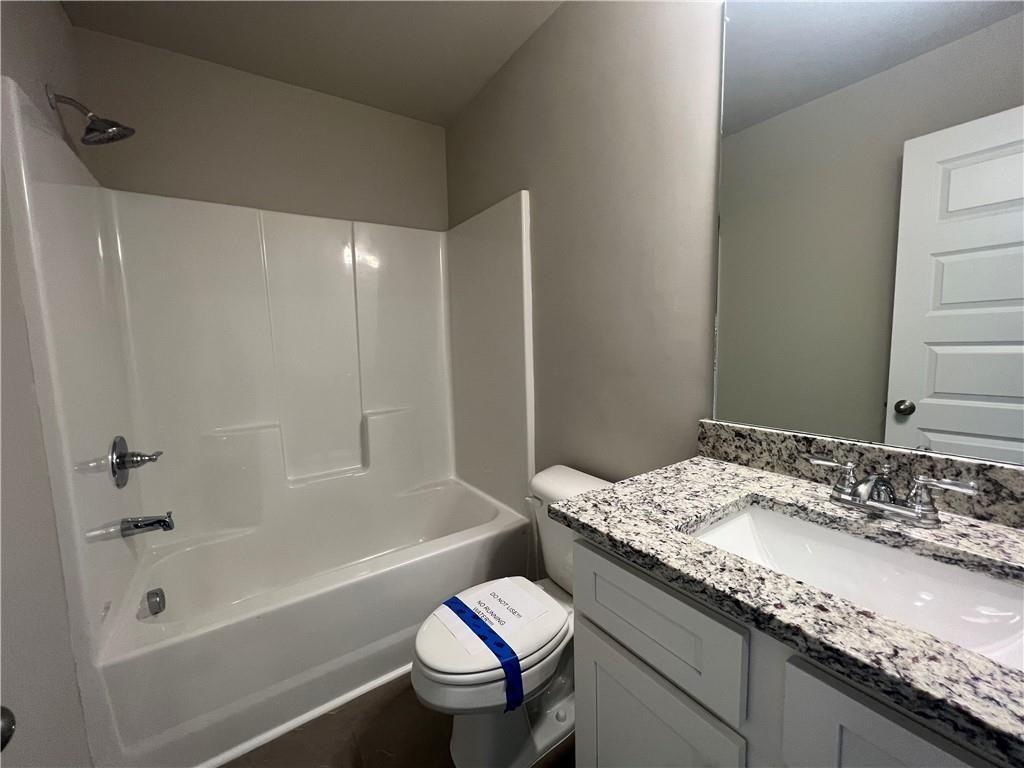 213 Cornwell Way Calhoun, GA 30701 - Photo 14 of 18 a bathroom with a granite countertop bathtub sink vanity mirror and toilet