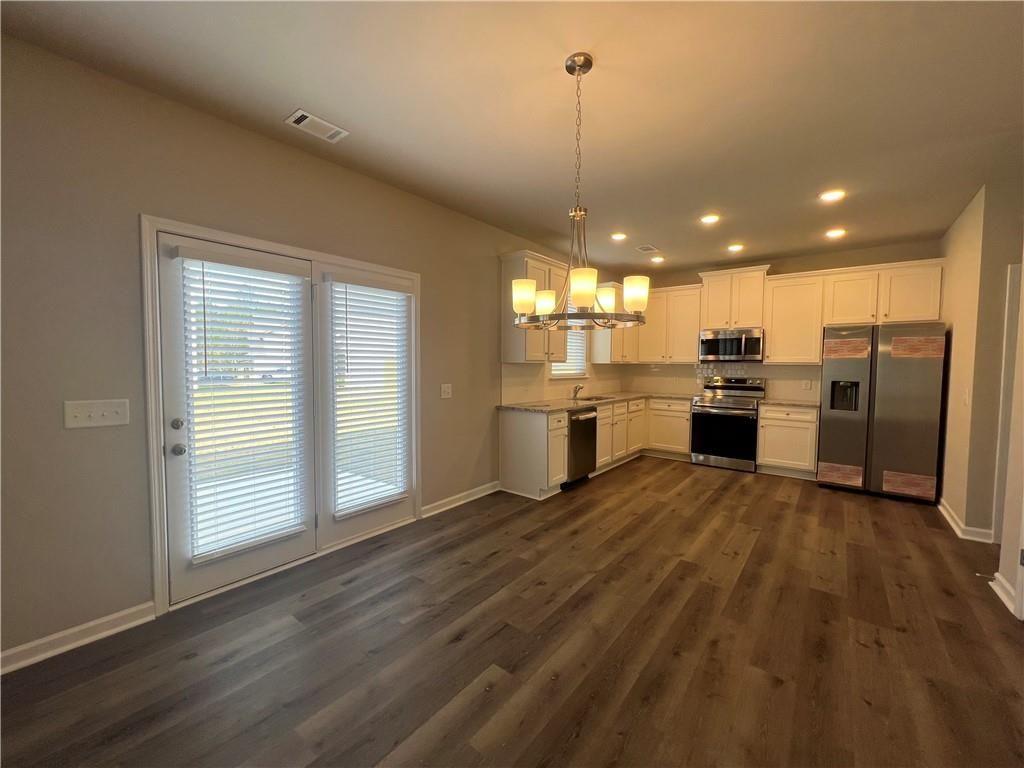 213 Cornwell Way Calhoun, GA 30701 - Photo 6 of 18 a view of a kitchen with a stove cabinets and a floor to ceiling window