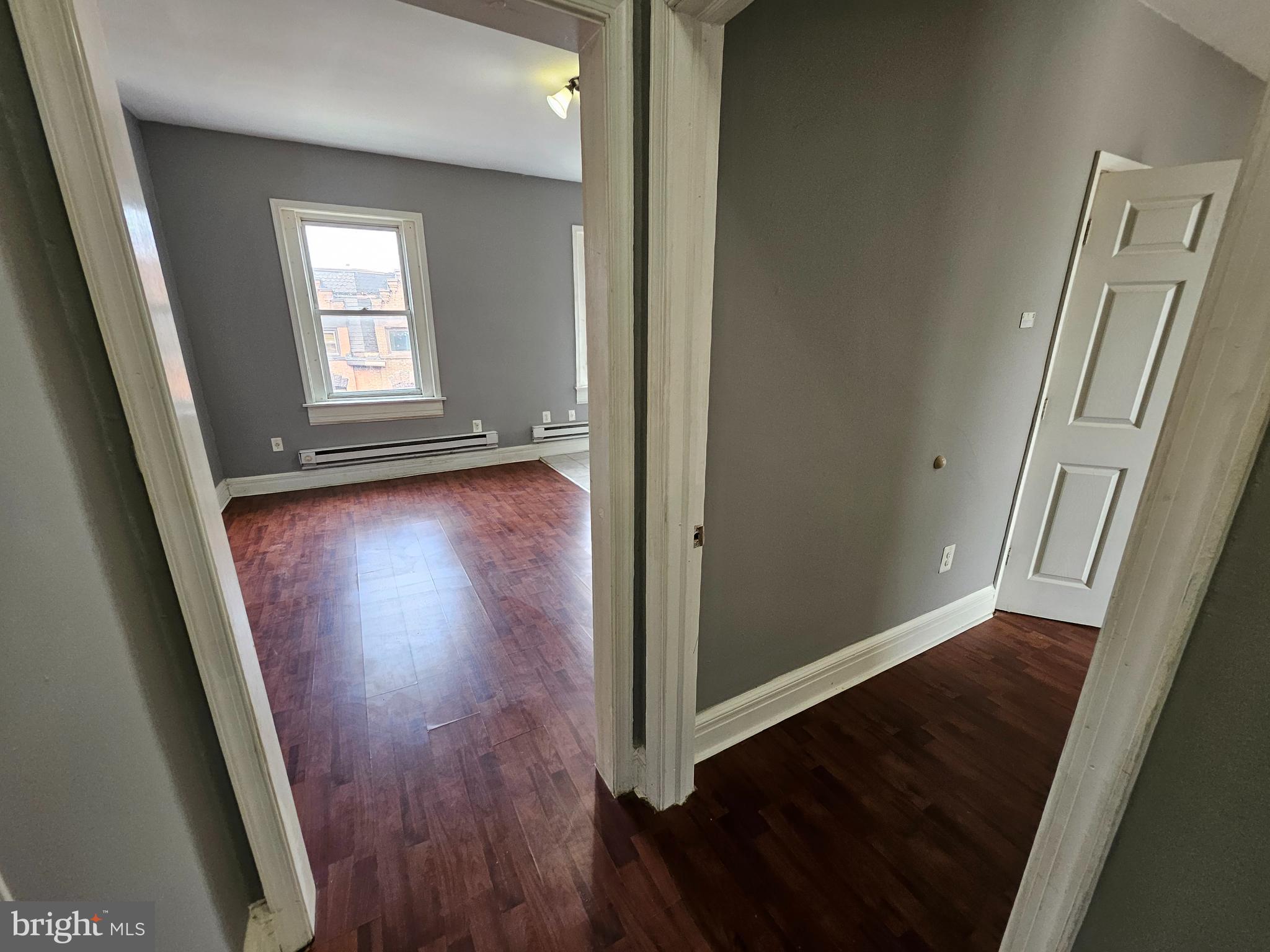 1517 North 17th Street, Unit 3F Philadelphia, PA 19121 - Photo 5 of 7 an empty room with wooden floor and windows