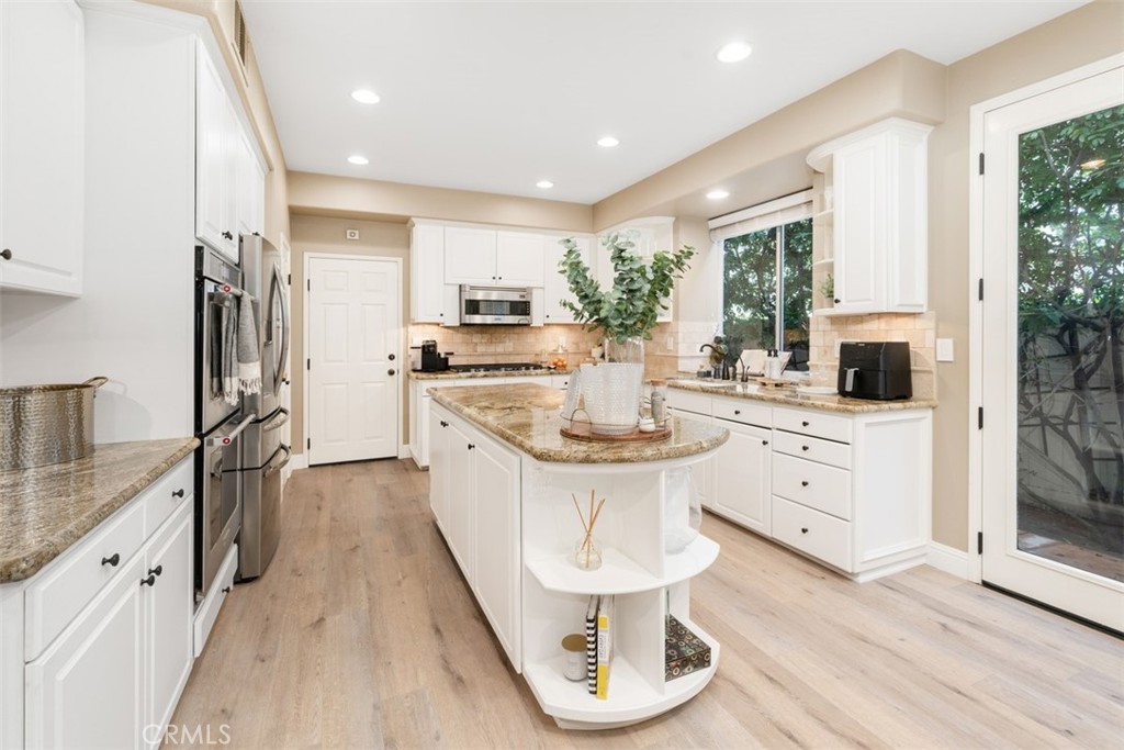 48 Creek View Road Coto de Caza, CA 92679 - Photo 8 of 39 a kitchen with white cabinets and stainless steel appliances