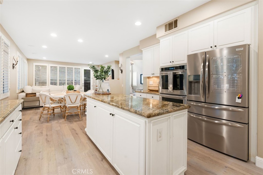48 Creek View Road Coto de Caza, CA 92679 - Photo 10 of 39 a kitchen with stainless steel appliances granite countertop a refrigerator a sink dishwasher a stove and white cabinets with wooden floor