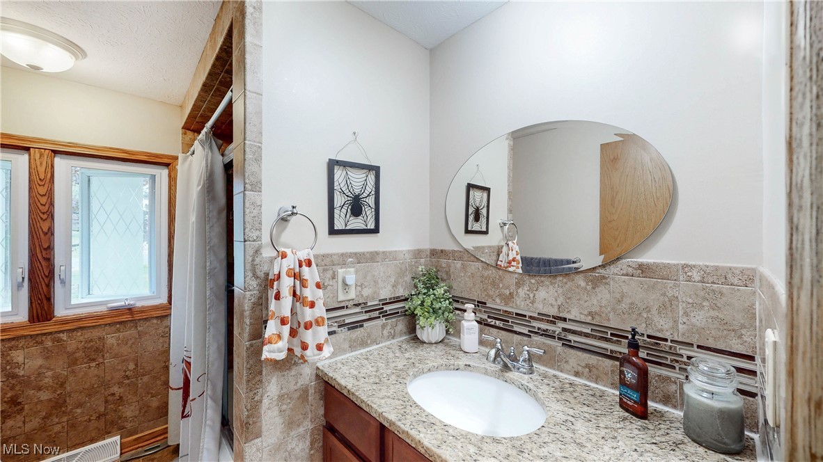 3123 Clearview Road Ravenna, OH 44266 - Photo 24 of 44 Full bath with vanity, tile walls, and a stall shower
