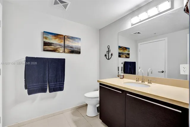 a living room with furniture floor to ceiling window and potted plants
