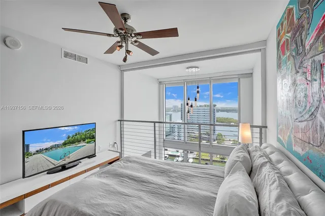 a bedroom with a bed and a painting on the wall