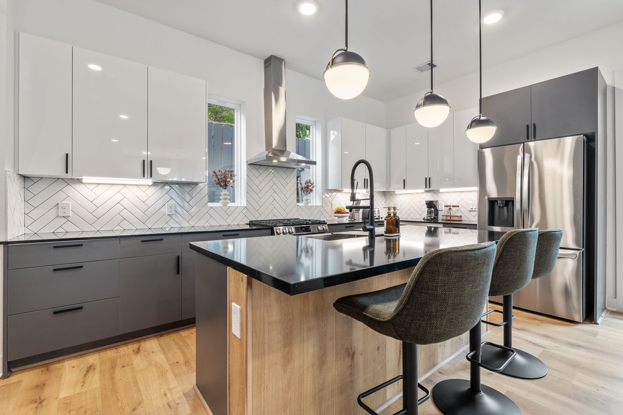 5502 Texas Street Houston, TX 77011 - Photo 5 of 33 a kitchen with stainless steel appliances granite countertop a sink a stove a refrigerator and island with wooden floor