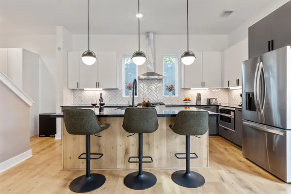 a kitchen with stainless steel appliances granite countertop a dining table cabinets and a sink